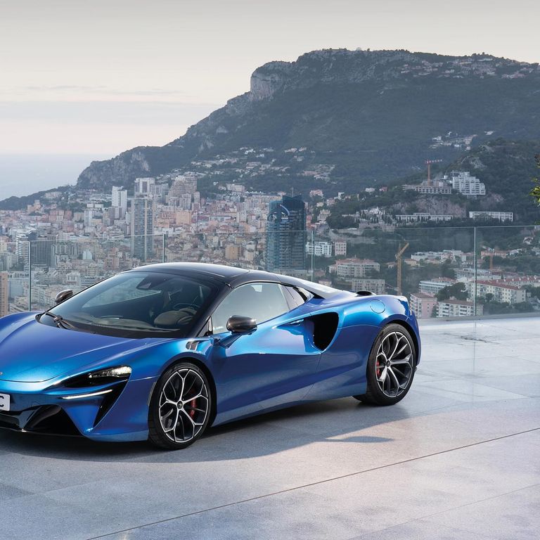 McLaren Artura Spider bleue devant Monaco, vue de trois quarts avant.